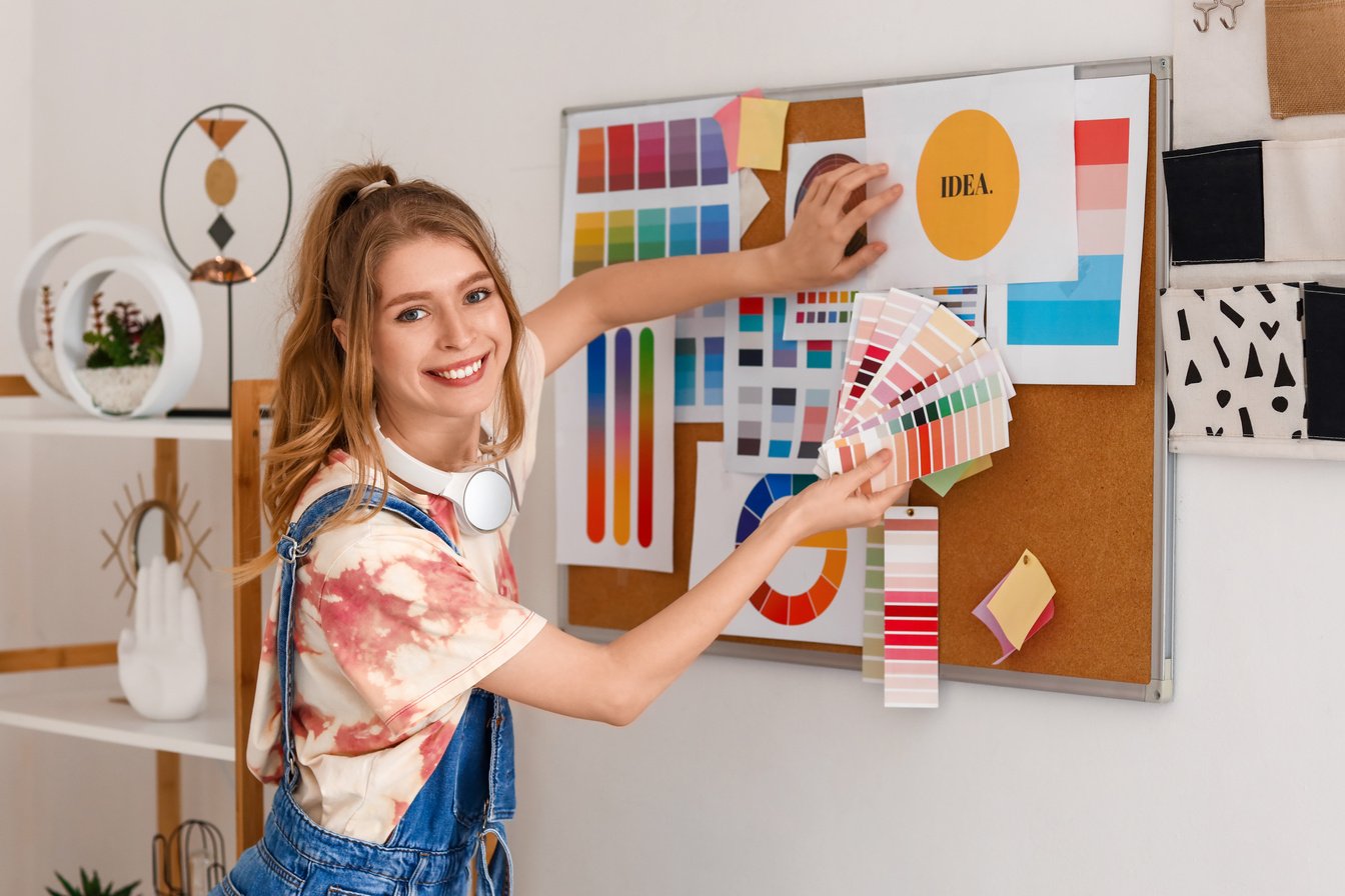 Female Graphic Designer with Color Palettes near Pinboard in Office